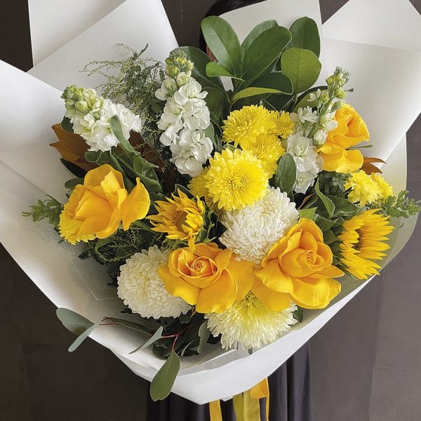 Bright and happy mix of inviting yellow and white flowers in an artfully arranged presentation style bouquet